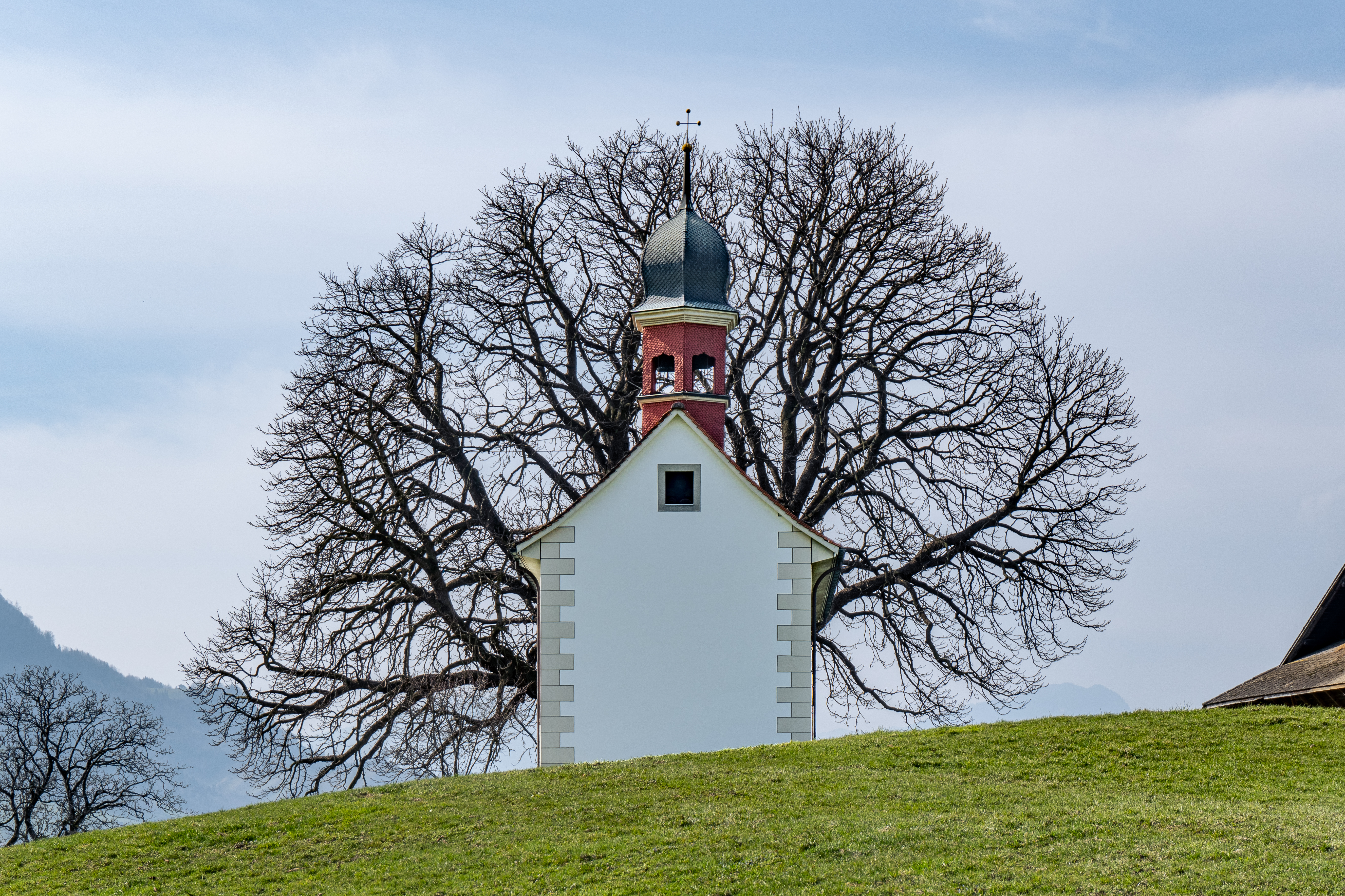 Auf dem Bild der im neugotischen Baustil errichteten Loretokapelle Ennerberg in Oberdorf erstrahlt eine malerische Kapelle in einer idyllischen Lage und einem bezaubernden Glockenturm, die eine Atmosphäre der Spiritualität und Ruhe vermittelt.